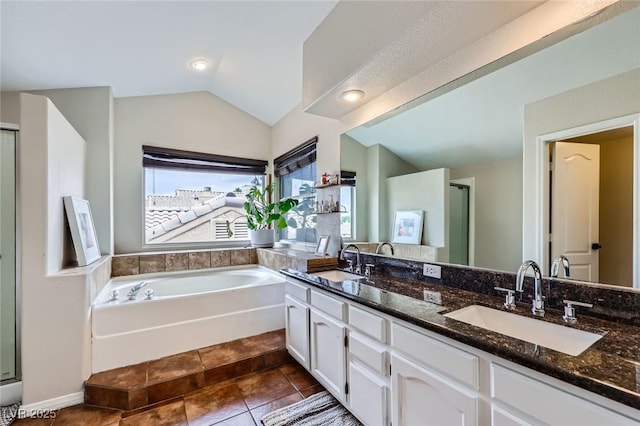 2535 Cortina Ave, Henderson, NV 89074 - full bathroom featuring vaulted ceiling, double vanity, a bath, a stall shower, and tile patterned floors