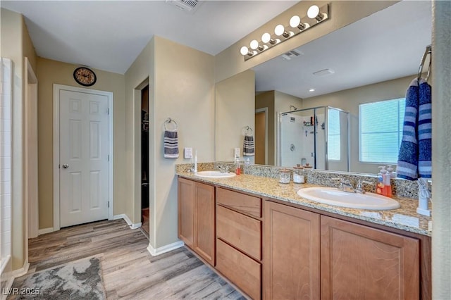 6322 Highledge St, North Las Vegas, NV 89081 - bathroom featuring a shower stall, wood finished floors, double vanity, and a spacious closet