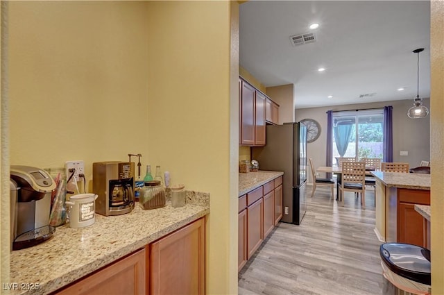 6322 Highledge St, North Las Vegas, NV 89081 - kitchen featuring light wood finished floors, freestanding refrigerator, light stone countertops, hanging light fixtures, and recessed lighting