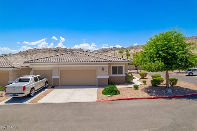 3251 Pheasant Hills Way, Laughlin, NV 89029 - view of front of property with a mountain view, a garage, driveway, stucco siding, and a tiled roof