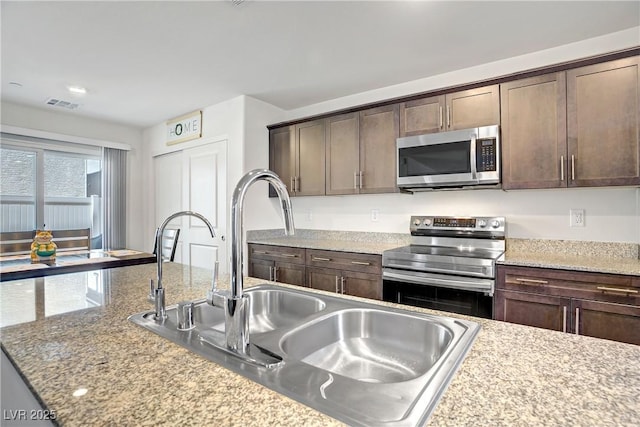 6831 Crimson Shadow St, North Las Vegas, NV 89086 - kitchen with stainless steel appliances and dark brown cabinets