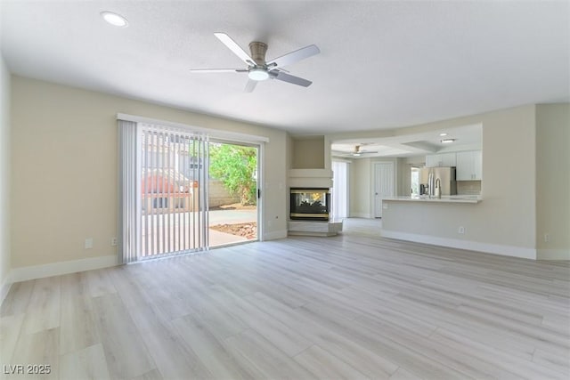 1846 Autumn Gold Ave, Las Vegas, NV 89123 - unfurnished living room with ceiling fan, light wood-style flooring, recessed lighting, and a multi sided fireplace
