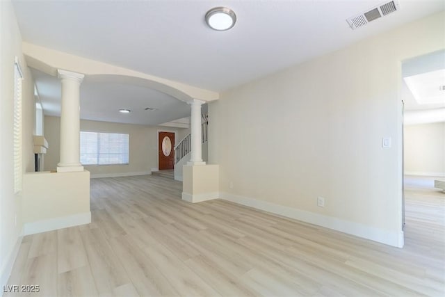 1846 Autumn Gold Ave, Las Vegas, NV 89123 - unfurnished living room featuring decorative columns, light wood-style flooring, arched walkways, and stairs