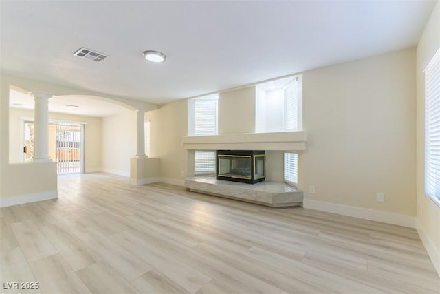 1846 Autumn Gold Ave, Las Vegas, NV 89123 - unfurnished living room with ornate columns, a tiled fireplace, wood finished floors, and arched walkways