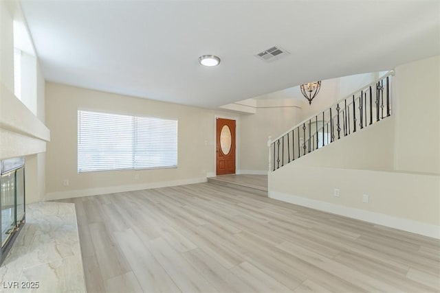 1846 Autumn Gold Ave, Las Vegas, NV 89123 - unfurnished living room featuring a chandelier, stairway, wood finished floors, and a high end fireplace