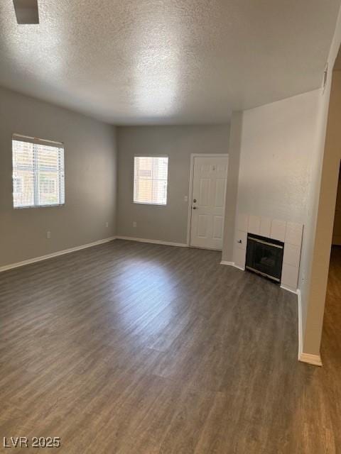 5250 S Rainbow Blvd Unit 1155, Las Vegas, NV 89118 - unfurnished living room featuring dark wood-style flooring, a fireplace, and a textured ceiling