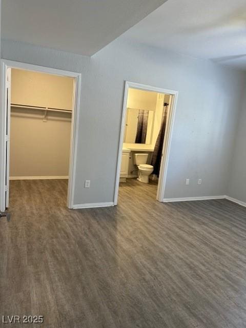 5250 S Rainbow Blvd Unit 1155, Las Vegas, NV 89118 - unfurnished bedroom with a walk in closet, dark wood-style floors, a closet, and connected bathroom