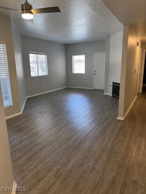 5250 S Rainbow Blvd Unit 1155, Las Vegas, NV 89118 - unfurnished living room featuring a ceiling fan, dark wood-style floors, a fireplace, and a textured ceiling
