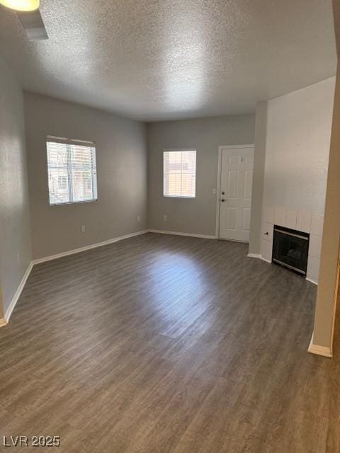 5250 S Rainbow Blvd Unit 1155, Las Vegas, NV 89118 - unfurnished living room with dark wood-style floors, a fireplace, and a textured ceiling