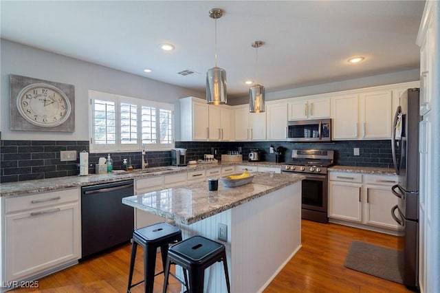 212 Stour Ln, Las Vegas, NV 89144 - kitchen featuring stainless steel appliances, white cabinetry, a center island, tasteful backsplash, and recessed lighting