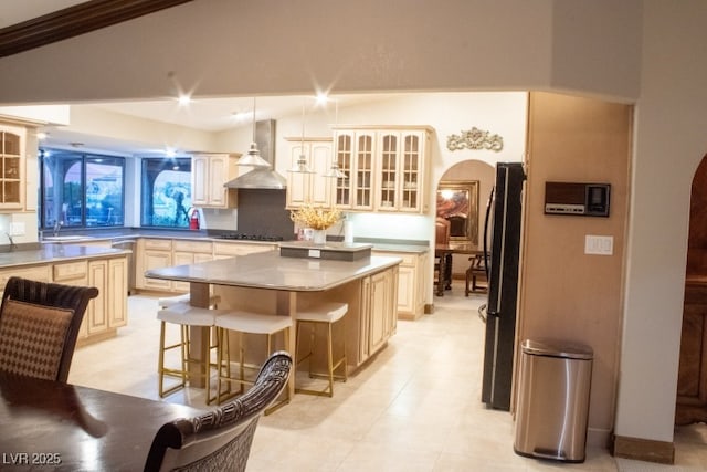 3430 Tanto Cir, Las Vegas, NV 89121 - kitchen with wall chimney range hood, arched walkways, and glass insert cabinets