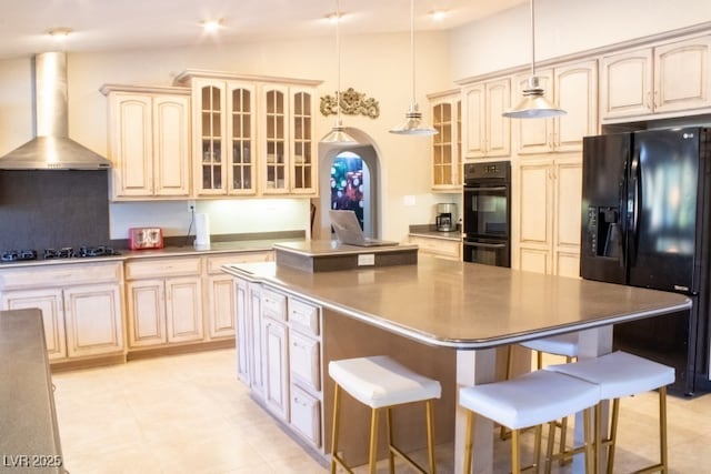 3430 Tanto Cir, Las Vegas, NV 89121 - kitchen with black appliances, wall chimney exhaust hood, a kitchen island, a kitchen breakfast bar, and glass insert cabinets