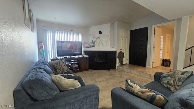 2941 Country Manor Ln Unit 27, Las Vegas, NV 89115 - living room featuring light tile patterned floors, a textured wall, and a fireplace