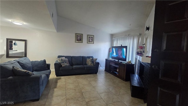 2941 Country Manor Ln Unit 27, Las Vegas, NV 89115 - living room with light tile patterned flooring, a fireplace with raised hearth, and vaulted ceiling
