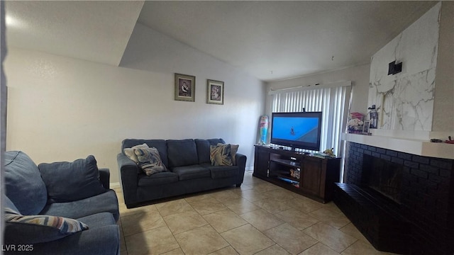 2941 Country Manor Ln Unit 27, Las Vegas, NV 89115 - living room featuring a fireplace, vaulted ceiling, and light tile patterned flooring