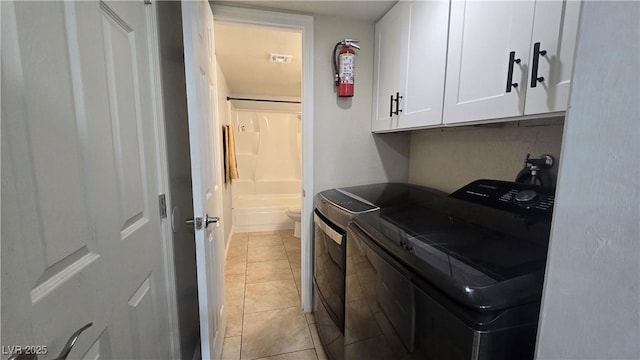 2941 Country Manor Ln Unit 27, Las Vegas, NV 89115 - laundry area with cabinet space, washer and dryer, and light tile patterned floors
