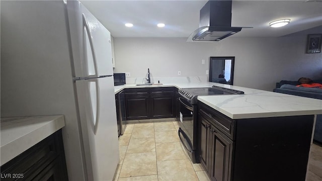 2941 Country Manor Ln Unit 27, Las Vegas, NV 89115 - kitchen with freestanding refrigerator, electric range, island range hood, a peninsula, and light stone counters