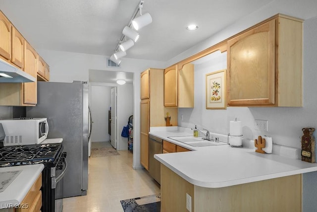 2902 Aztec Lily Ln, Henderson, NV 89074 - kitchen featuring appliances with stainless steel finishes, light countertops, light brown cabinetry, and a peninsula