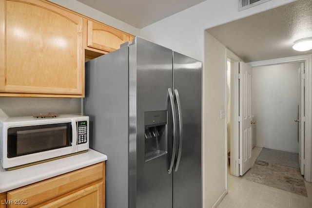 2902 Aztec Lily Ln, Henderson, NV 89074 - kitchen with white microwave, stainless steel fridge with ice dispenser, light brown cabinets, and light countertops