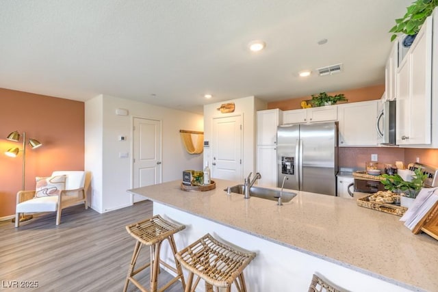 10988 Rollingford Ave Lot 10, Las Vegas, NV 89166 - kitchen with appliances with stainless steel finishes, a peninsula, light stone countertops, white cabinets, and recessed lighting