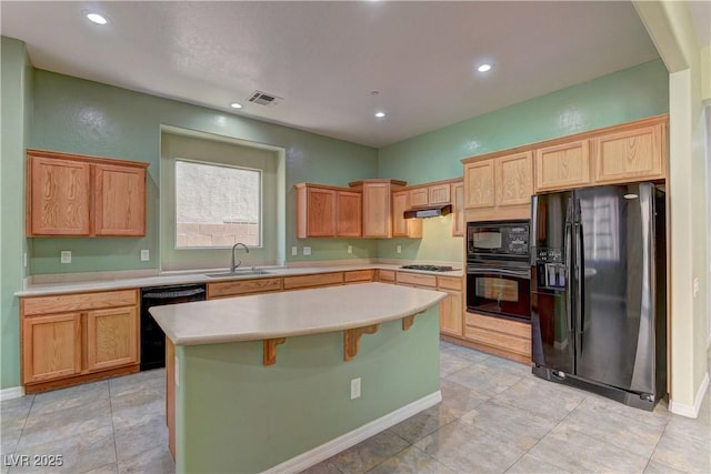 225 Palmetto Pointe Dr, Henderson, NV 89012 - kitchen with black appliances, light countertops, recessed lighting, a kitchen island, and under cabinet range hood