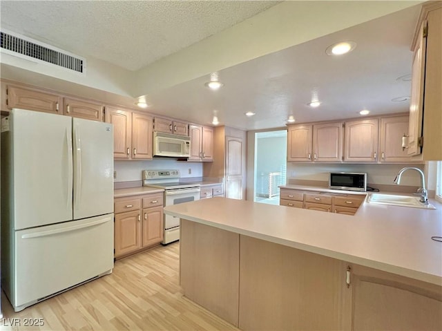 304 Broxton Ln, Las Vegas, NV 89107 - kitchen featuring white appliances, light brown cabinets, light wood-style floors, light countertops, and recessed lighting