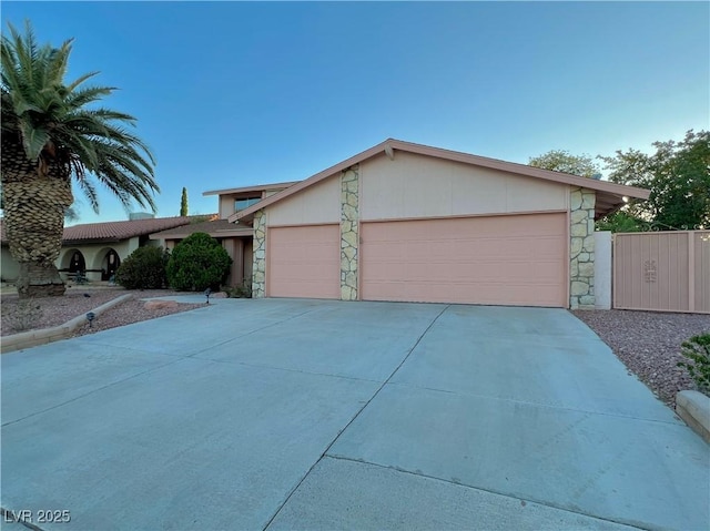 304 Broxton Ln, Las Vegas, NV 89107 - view of front facade featuring stone siding, an attached garage, and concrete driveway