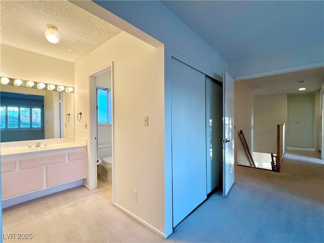 304 Broxton Ln, Las Vegas, NV 89107 - unfurnished bedroom featuring light colored carpet, a closet, ensuite bathroom, and a textured ceiling