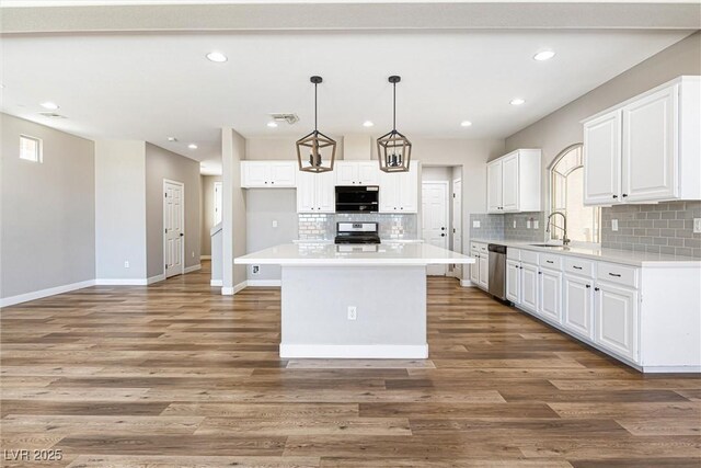 9432 Logan Ridge Ct, Las Vegas, NV 89139 - kitchen featuring stainless steel appliances, tasteful backsplash, white cabinetry, light countertops, and recessed lighting