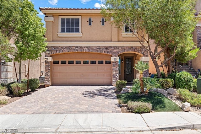 9432 Logan Ridge Ct, Las Vegas, NV 89139 - view of front facade with stucco siding, driveway, stone siding, and an attached garage