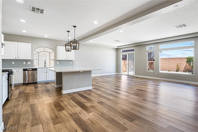 9432 Logan Ridge Ct, Las Vegas, NV 89139 - kitchen with appliances with stainless steel finishes, light countertops, a center island, dark wood-style flooring, and open floor plan
