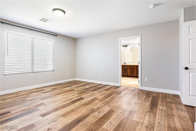 9432 Logan Ridge Ct, Las Vegas, NV 89139 - unfurnished bedroom with light wood finished floors and ensuite bathroom