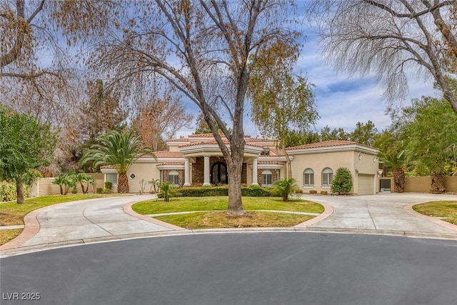 81 Quail Run Rd, Henderson, NV 89014 - mediterranean / spanish-style house with curved driveway, stucco siding, a tile roof, and a garage
