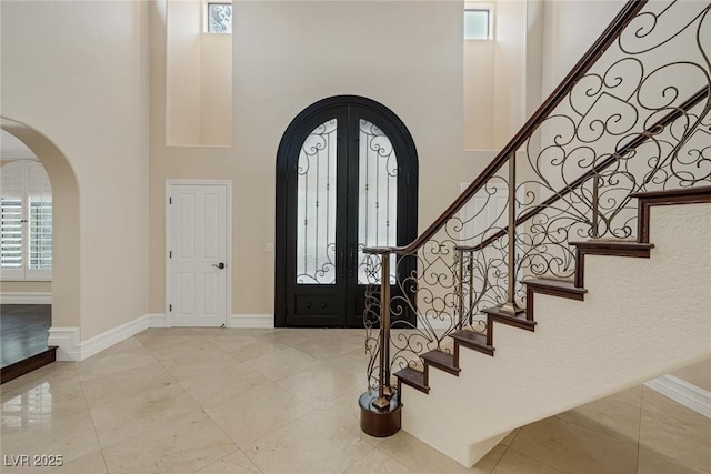 81 Quail Run Rd, Henderson, NV 89014 - entrance foyer with arched walkways, a towering ceiling, stairway, french doors, and tile patterned floors
