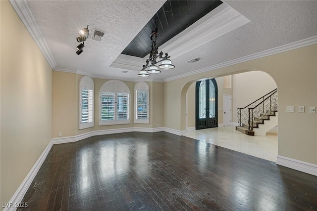 81 Quail Run Rd, Henderson, NV 89014 - empty room featuring arched walkways, a textured ceiling, hardwood / wood-style floors, stairway, and a raised ceiling