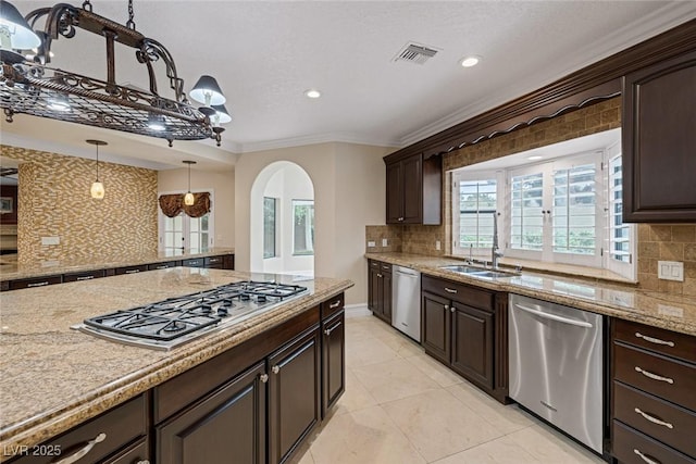 81 Quail Run Rd, Henderson, NV 89014 - kitchen featuring appliances with stainless steel finishes, arched walkways, decorative backsplash, crown molding, and dark brown cabinetry