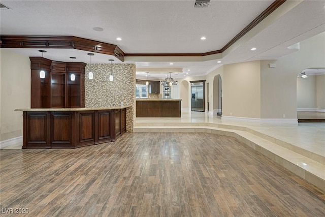 81 Quail Run Rd, Henderson, NV 89014 - unfurnished living room with arched walkways, light wood finished floors, ornamental molding, a textured ceiling, and a raised ceiling