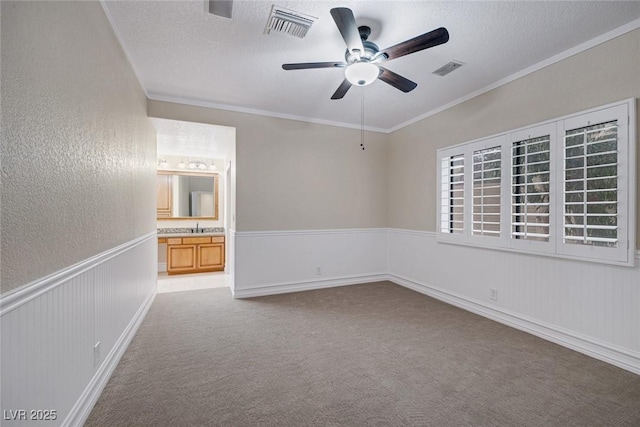 81 Quail Run Rd, Henderson, NV 89014 - unfurnished bedroom featuring ornamental molding, wainscoting, a textured ceiling, carpet, and connected bathroom
