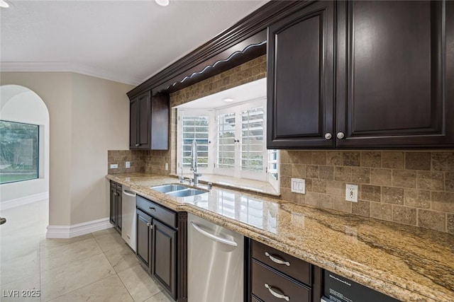 81 Quail Run Rd, Henderson, NV 89014 - kitchen with ornamental molding, stainless steel dishwasher, light stone countertops, decorative backsplash, and dark brown cabinetry