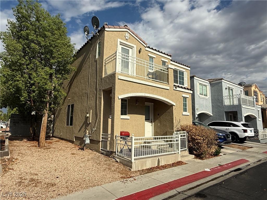 10322 Tranquil Breeze St, Las Vegas, NV 89183 - view of front facade with a balcony, covered porch, stucco siding, and a residential view
