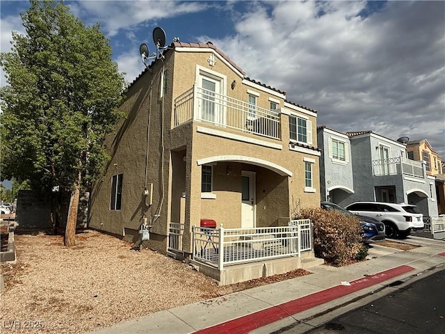 10322 Tranquil Breeze St, Las Vegas, NV 89183 - view of front facade with a balcony, covered porch, stucco siding, and a residential view