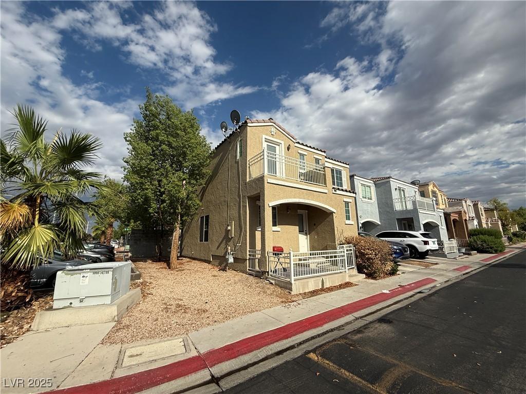 10322 Tranquil Breeze St, Las Vegas, NV 89183 - view of front of house featuring a balcony, stucco siding, a residential view, and covered porch