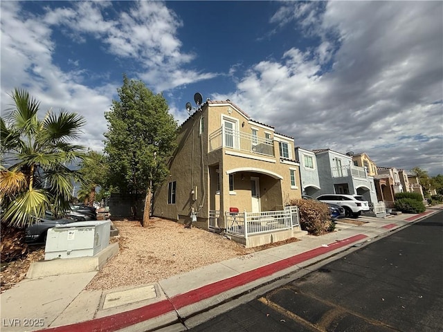 10322 Tranquil Breeze St, Las Vegas, NV 89183 - view of front of house featuring a balcony, stucco siding, a residential view, and covered porch