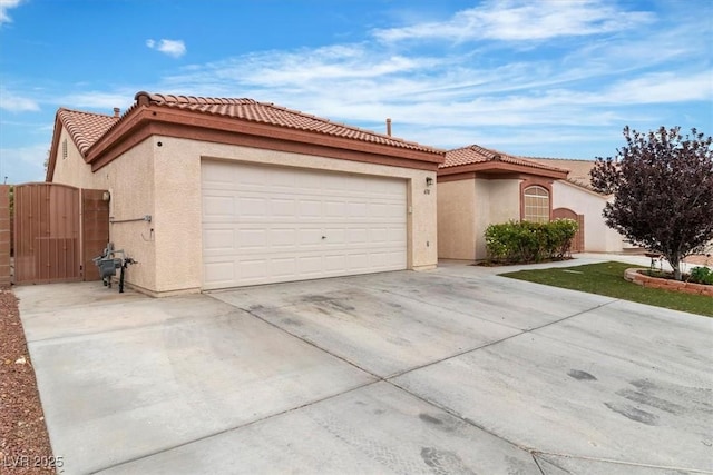658 Turtleback Dr, North Las Vegas, NV 89031 - view of front of house with stucco siding, concrete driveway, a tiled roof, an attached garage, and a gate