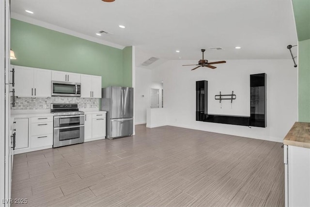 658 Turtleback Dr, North Las Vegas, NV 89031 - kitchen with stainless steel appliances, ceiling fan, open floor plan, backsplash, and white cabinets