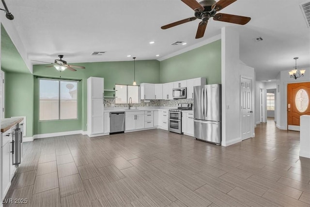658 Turtleback Dr, North Las Vegas, NV 89031 - kitchen featuring stainless steel appliances, ceiling fan, light countertops, white cabinets, and backsplash