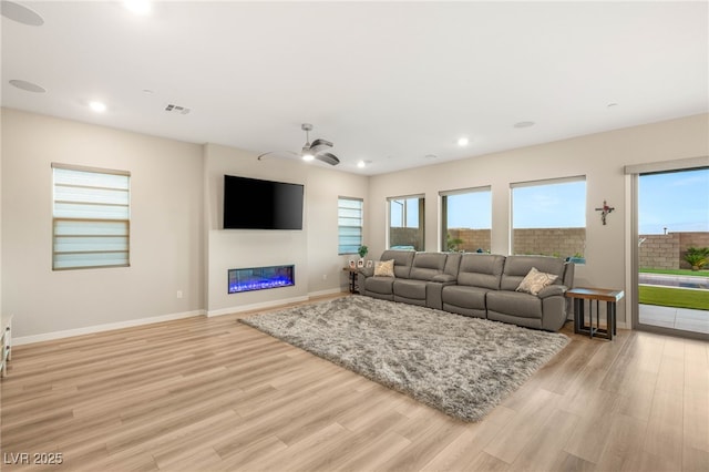 186 Vista Balla Ave, Las Vegas, NV 89138 - living room with light wood finished floors, recessed lighting, a glass covered fireplace, and ceiling fan