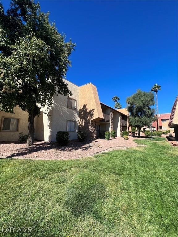 5350 River Glen Dr Unit 298, Las Vegas, NV 89103 - view of front facade with stucco siding and a front lawn