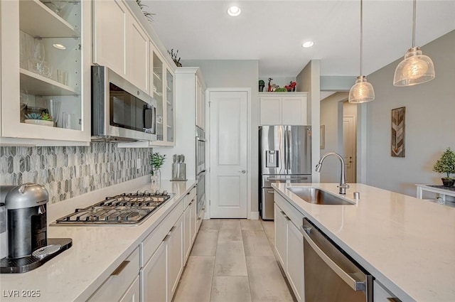 9940 Heather Moore Ave, Las Vegas, NV 89166 - kitchen featuring stainless steel appliances, hanging light fixtures, white cabinetry, tasteful backsplash, and glass insert cabinets