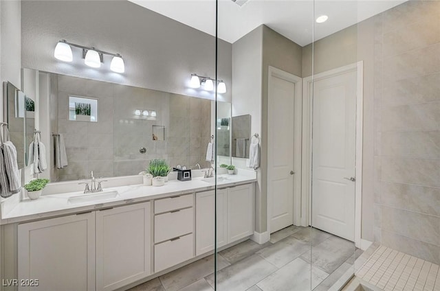 9940 Heather Moore Ave, Las Vegas, NV 89166 - full bathroom with double vanity, marble finish flooring, tile walls, and a walk in shower